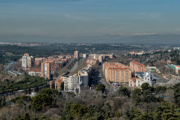 Fototapeta na wymiar view of some buildings in Madrid, the Manzanares river and the Guadarrama mountain range in the background. In Madrid. Spain