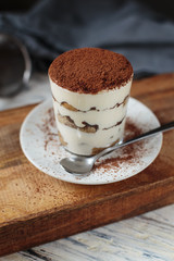 Italian dessert tiramisu closeup on wooden table, mint