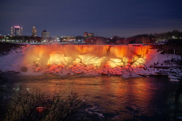 Niagara Falls CANADA - February 23, 2019: Winter frozen night view at the American side of beautiful Niagara Falls cower with colorful lights on snow and ice