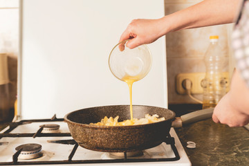 chef pouring sauce at the frying pan