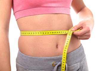 sport, fitness and diet concept, trained belly with measuring tape, health
