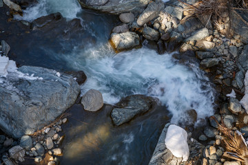 Whirlpool of mountain river on a sunny winter day
