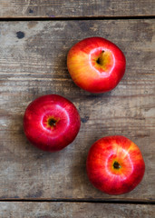 Ripe red apples on dark wooden surface, top view. From above, overhead.