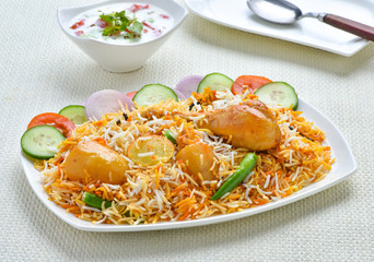 Chicken Biryani, A famous Indian Sub-continent savory rice dish mixed with spicy marinated chicken, spices and flavorful saffron.