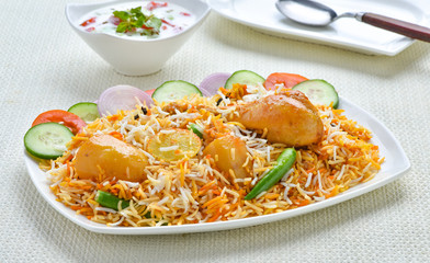 Chicken Biryani, A famous Indian Sub-continent savory rice dish mixed with spicy marinated chicken, spices and flavorful saffron.