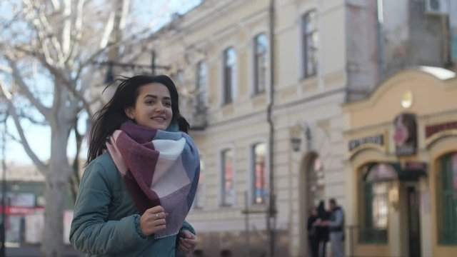 Sportive girl with waving long hair moving in a street in winter in slow motion  