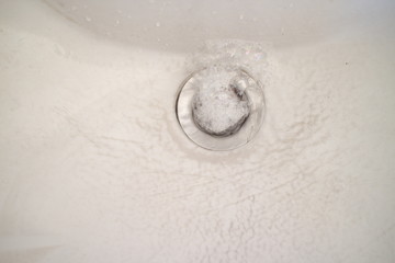 water flowing into the sink with foam