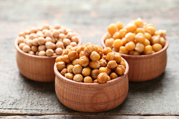 Roasted and dry chickpeas in bowls on grey wooden table