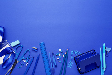 School supplies on blue background. Minimalism concept