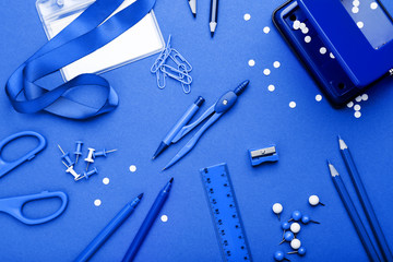 School supplies on blue background. Minimalism concept