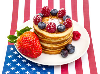 Heap of pancakes with berries on USA flag