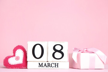 Women's Day on wooden calendar with fabric heart and gift box