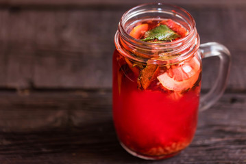 Fototapeta na wymiar Close up glass jar with delicious healthy raspberry tea drink