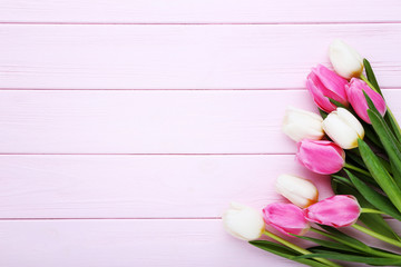 Bouquet of tulips on pink wooden table