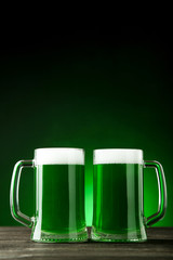 St. Patrick's Day. Glass mugs with green beer on dark background