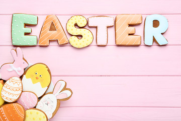 Gingerbread cookies and word Easter on pink wooden table