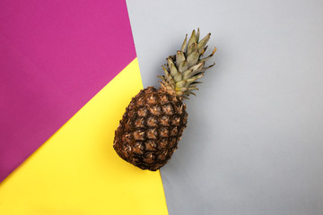 top view of pineapple on colored paper.