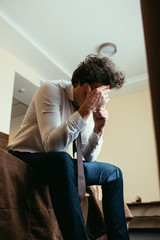 frustrated businessman talking on smartphone in hotel room