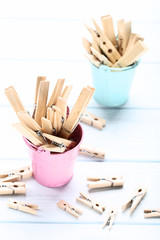 Brown clothespins in buckets on wooden table