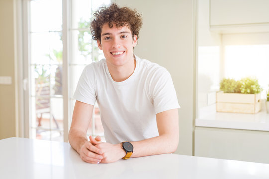 Young handsome man wearing white t-shirt at home with a happy and cool smile on face. Lucky person.