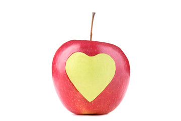 Obraz premium Red apple with cutout heart shape on white background