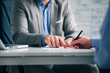 Lawyer showing a client where to sign a legal document, close-up.