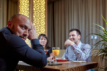 The third is superfluous. couple in love is having dinner in a restaurant with a lonely friend