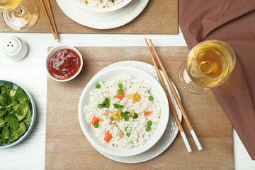 Boiled rice with vegetables served on table, flat lay