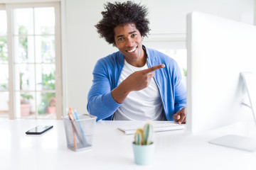 African American man working using computer very happy pointing with hand and finger