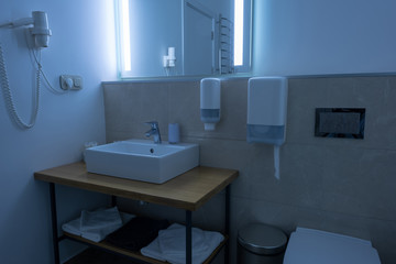 bathroom with washstand, toilet, towels and hair dryer