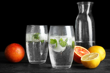 Composition with refreshing drink with mint and ice cubes in glasses on dark background