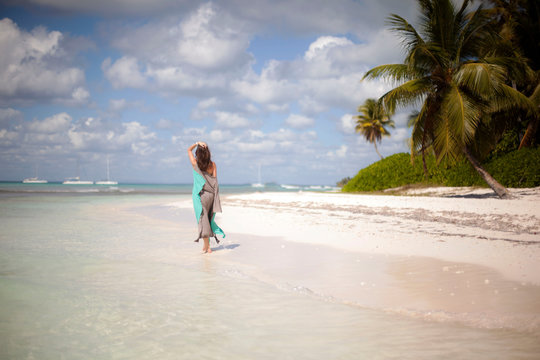 Woman walks on a tropical beach - Stock image