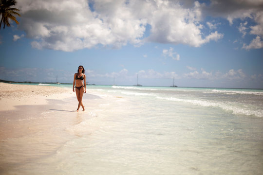 Woman walks on a tropical beach