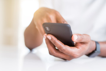 Close up of african american man hands using smartphone