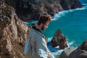 Man relaxing on rocky cliff Cabo da Roca, Portugal