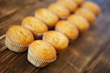 Delicious golden cupcakes on a wooden surface of pine boards. Tasty and healthy food. Diagonal perspective and shallow depth of field