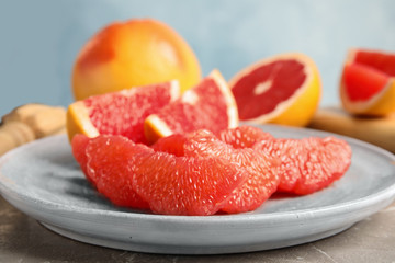 Plate with ripe grapefruit on table. Fresh fruit