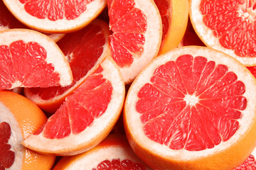 Naklejka na ściany i meble Many sliced fresh ripe grapefruits as background, closeup