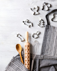 Kitchen apron on Holiday Background Concept of Christmas and New Year. Festive preparations. Poster design, rolling and whisk, a wooden spoon and cookie cutters and gingerbread. Copy space for Text.