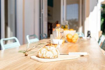 Table set for breakfast with bread in foreground