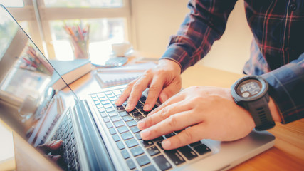 Fototapeta na wymiar Man's hands typing on laptop keyboard