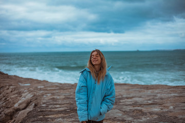 Woman relaxing on rocky cliff Cabo da Roca, Portugal