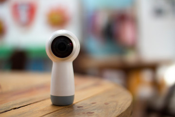 360 camera for virtual reality videos on a wooden table with blurred background