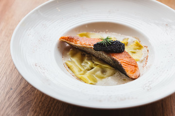 Ravioli in cream sauce with Grilled Salmon topping with Caviar.