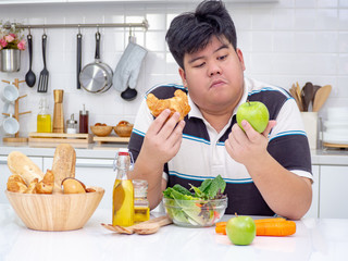 Diet fat Asian man who makes choice between healthy and unhealthy food.
