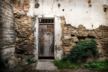 Fototapeta na wymiar Abandoned wall with wooden door in Antigua, Guatemala, Central America