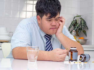 Asian fat man are taking medicines and vitamins for help Sick and healthy.