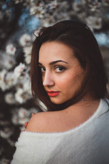 Belle jeune femme au milieu des amandiers en fleurs