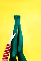 Pop art piece of young woman legs in tights against a yellow background