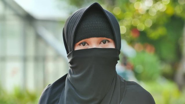 Portrait of a young muslim girl in a black hijab.